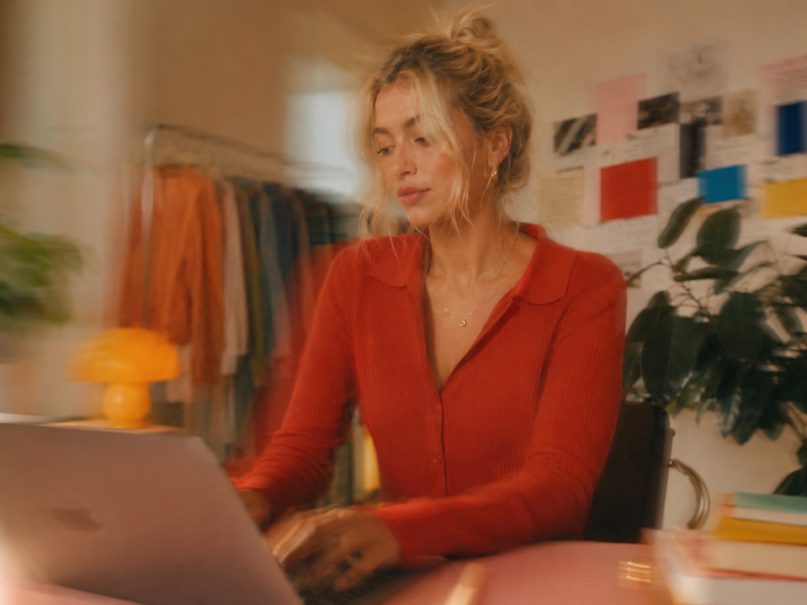Someone working on a laptop at a warm, creative desk