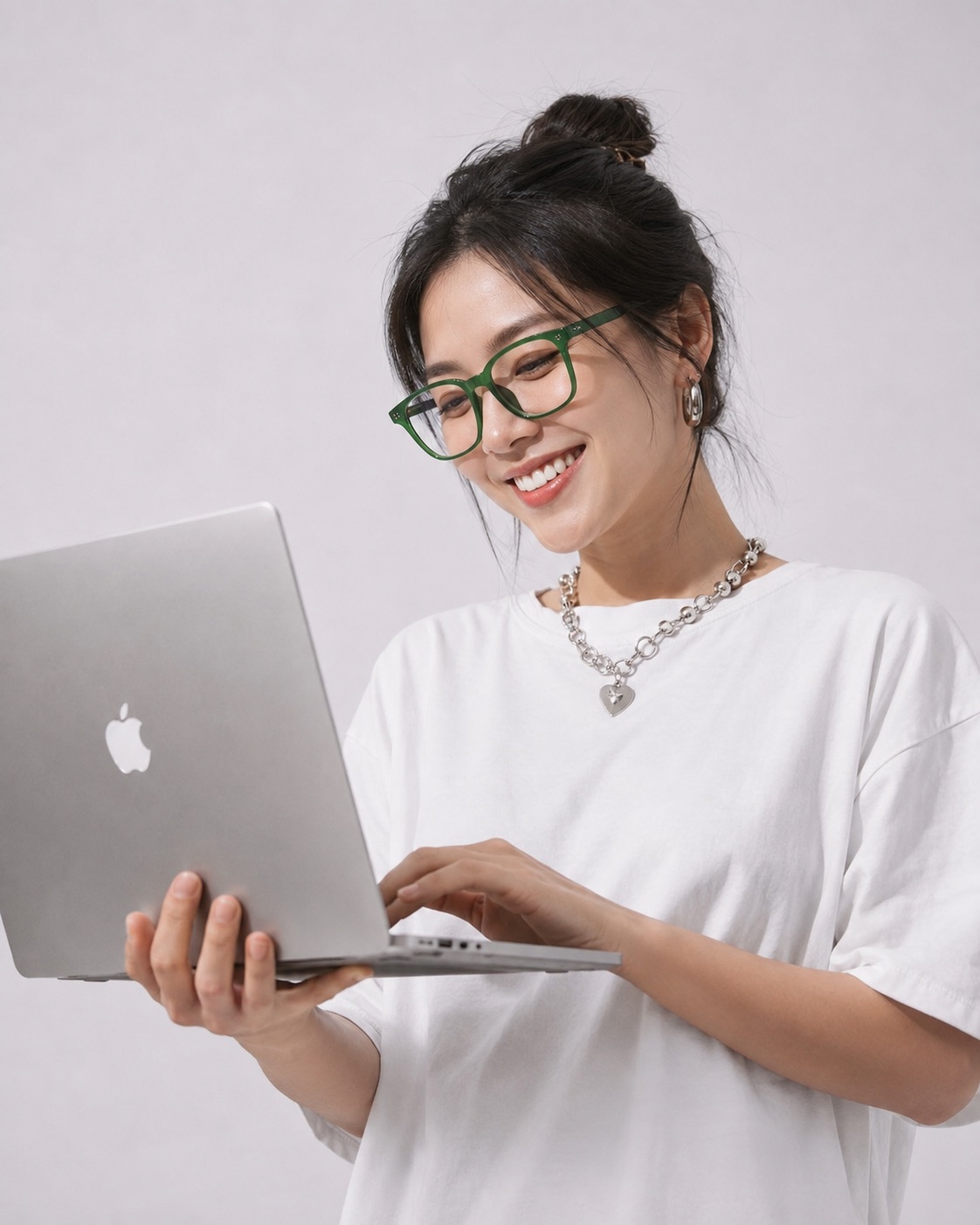 A creator smiling at a MacBook held in one hand